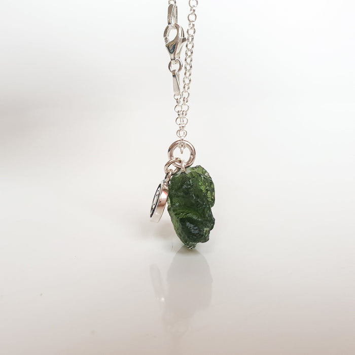 Necklace with a green stone pendant on a white background