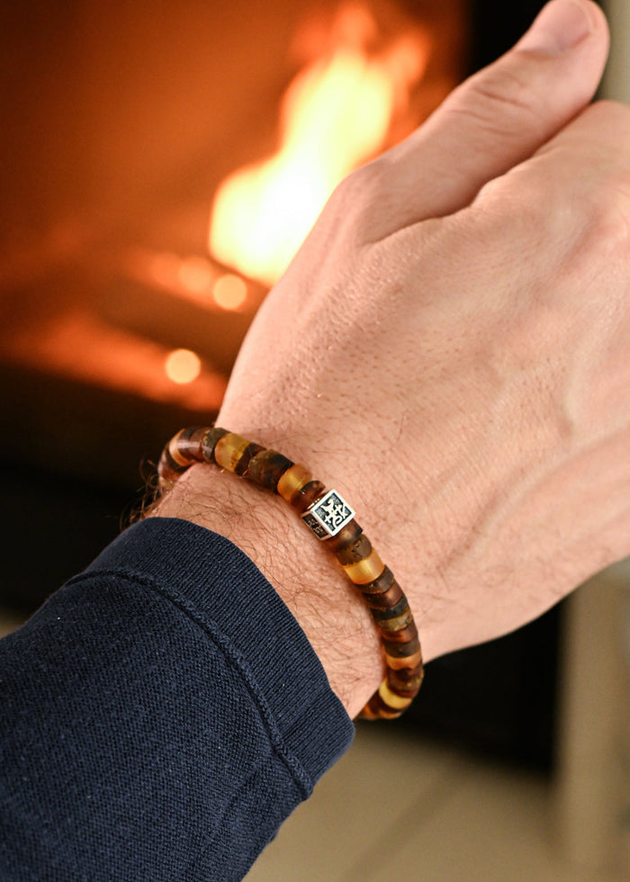 Hand wearing a beaded Baltic amber mens bracelet