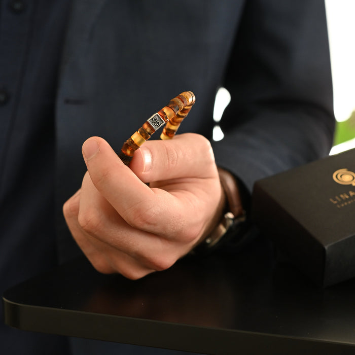 Hand holding a decorative item with a blurred background