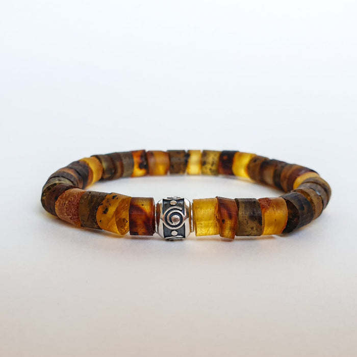A bracelet made of natural amber beads with a silver 925 accent bead featuring a spiral design, displayed against a white background.