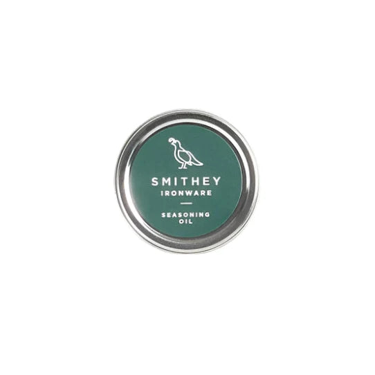 Smithey Ironware 1310 Specialty Cast Iron and Carbon Steel Seasoning Oil bottle on a kitchen countertop.