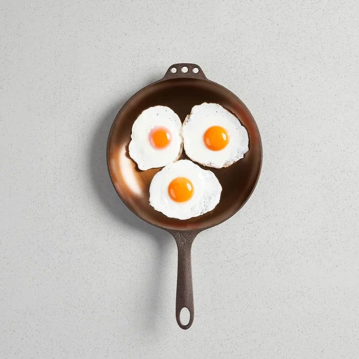 Smithey Ironware 10-inch cast iron chef skillet with a smooth black finish, shown in a close-up view on a kitchen countertop.