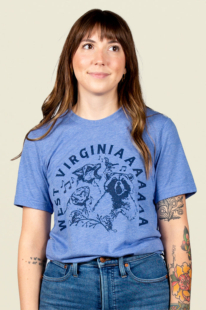 Kin Ship Goods heather blue country critters tee with howling Appalachian animals and ‘West Virginiaaaaa’ text, perfect for nature lovers and locals.