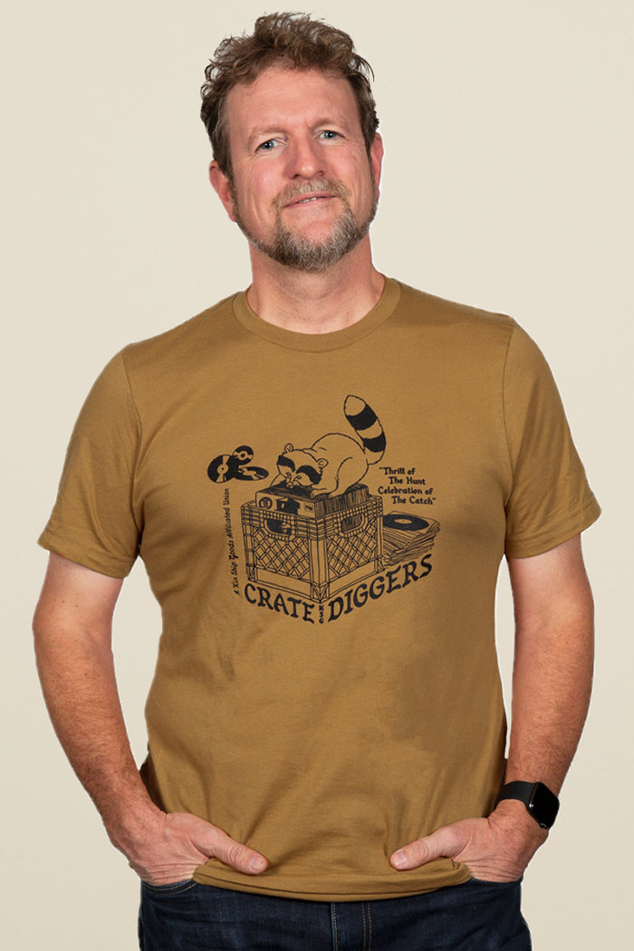 Kin Ship Goods brown unisex tee with raccoon crate-digging vinyl record graphic and ‘Crate Diggers’ retro-style text.