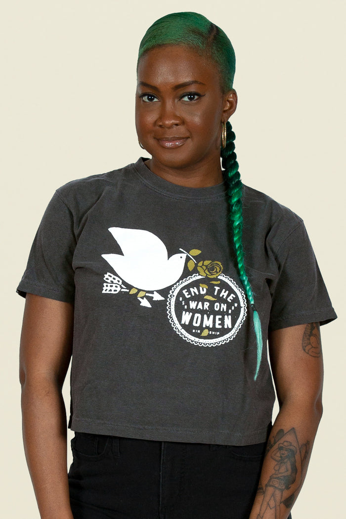 End the War on Women cropped tee from Kin Ship Goods – vintage-wash black shirt featuring a peace dove and bold feminist message. Ethically made.