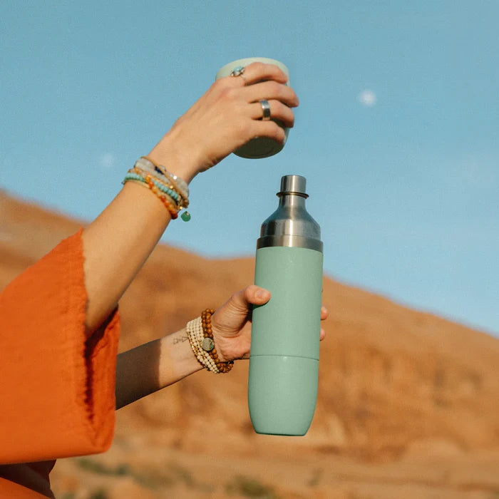 High Camp Parkside Flask in Juniper Green held by a model at Addison West
