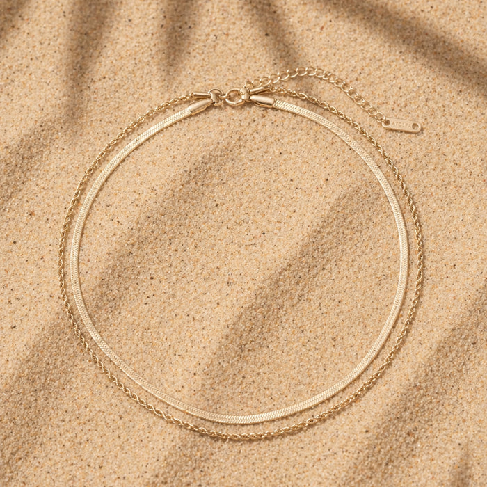 Ios Layered 14k Gold Bracelet Flat Lay On Sand, Double Chain Waterproof Jewelry