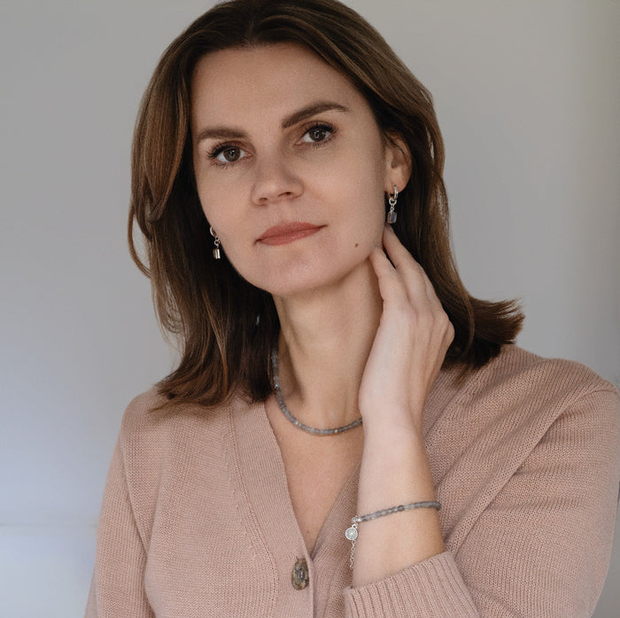 Woman wearing jewelry against a neutral background