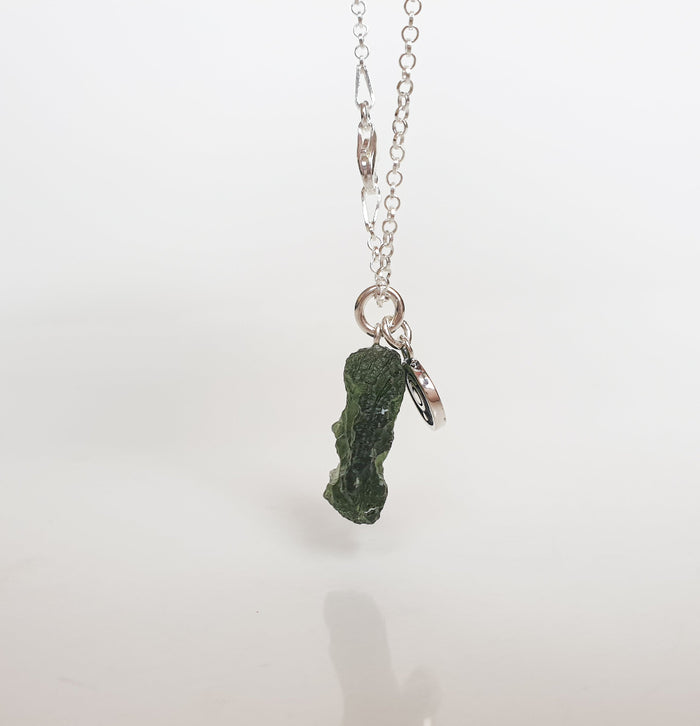 Necklace with a green stone pendant on a white background