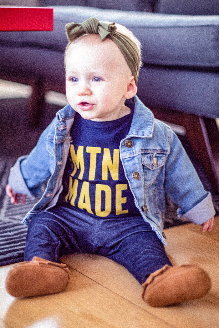 Kin Ship Goods navy baby onesie with bold gold ‘MTN MADE’ print, celebrating West Virginia roots and Appalachian pride.