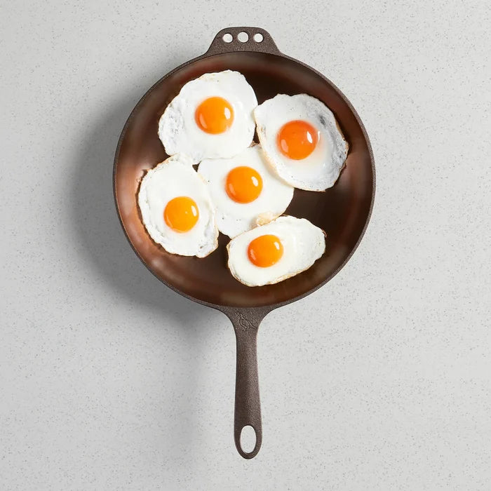 Smithey Ironware No. 11 cast iron skillet with glass lid, deep frying pan with smooth black surface and sturdy handle.