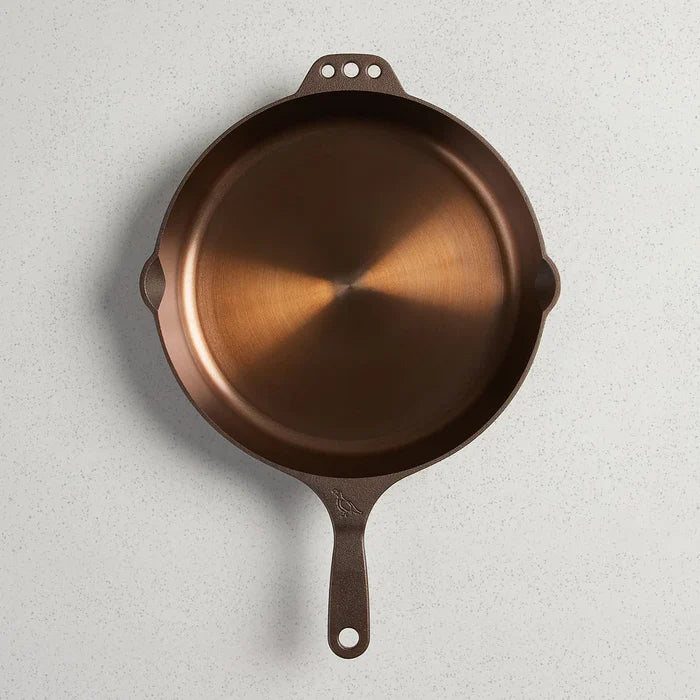 Smithey Ironware No. 12 cast iron skillet with a seasoned black finish, showcasing its sturdy, smooth cooking surface.