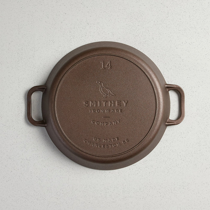 Smithey Ironware No. 14 dual handle cast iron skillet with a smooth cooking surface and sturdy handles, ready for stovetop use.