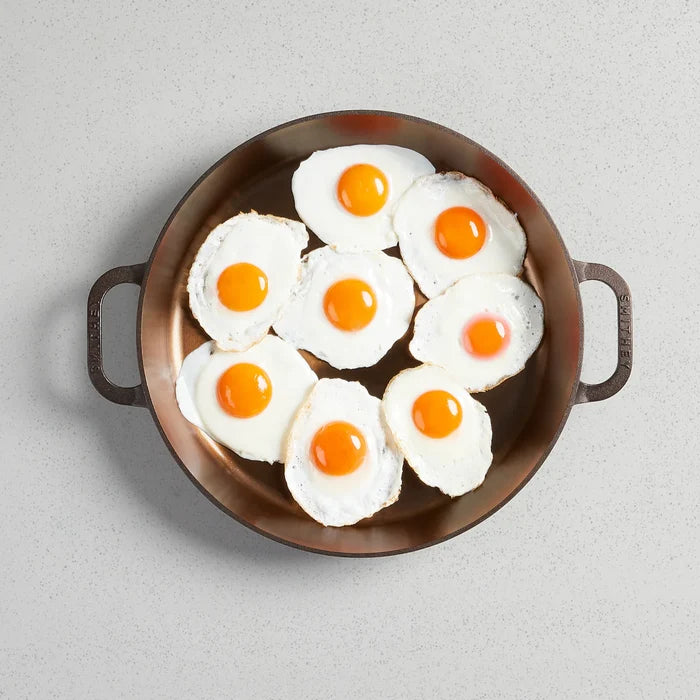 Smithey Ironware No. 14 dual handle cast iron skillet with smooth black surface and sturdy handles for versatile cooking.