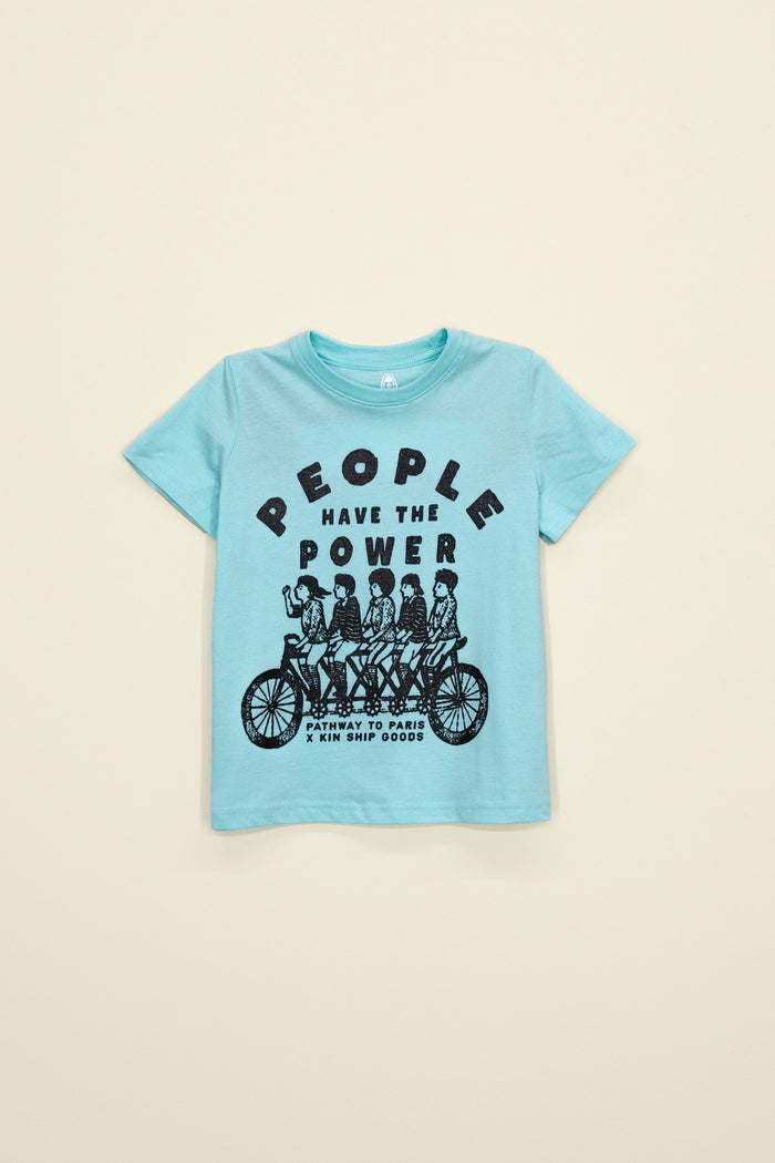 Kin Ship Goods kids tee in aqua with ‘People Have the Power’ tandem bike graphic, a Pathway to Paris collaboration design.