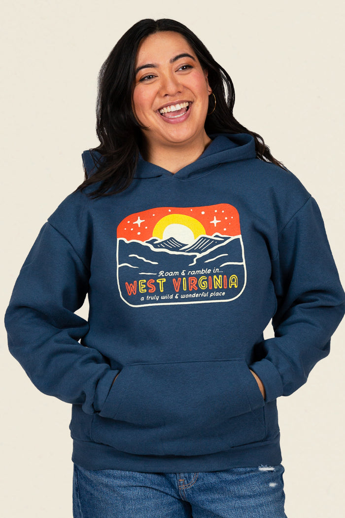 Kin Ship Goods retro West Virginia hoodie with mountain sunrise graphic and 'Roam & Ramble' text on navy blue fabric.