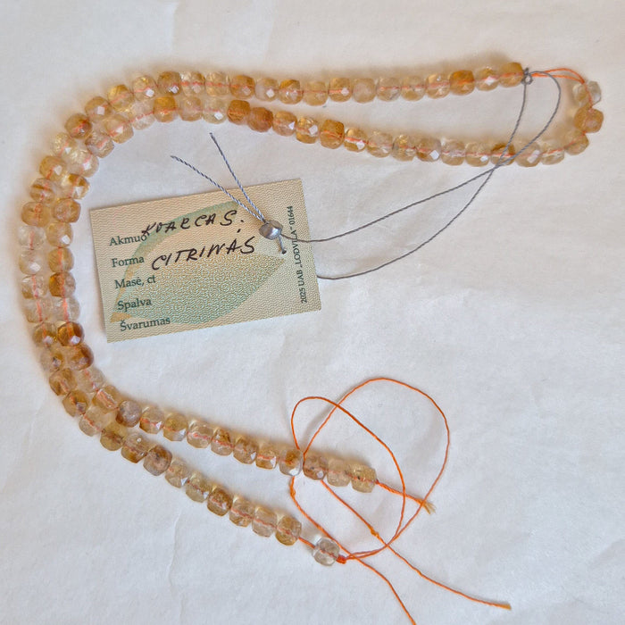 Beaded necklace with a tag on a white background