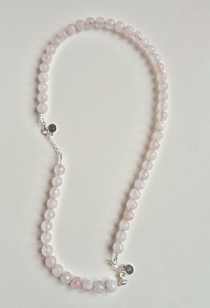 Necklace with pink beads on a light gray background