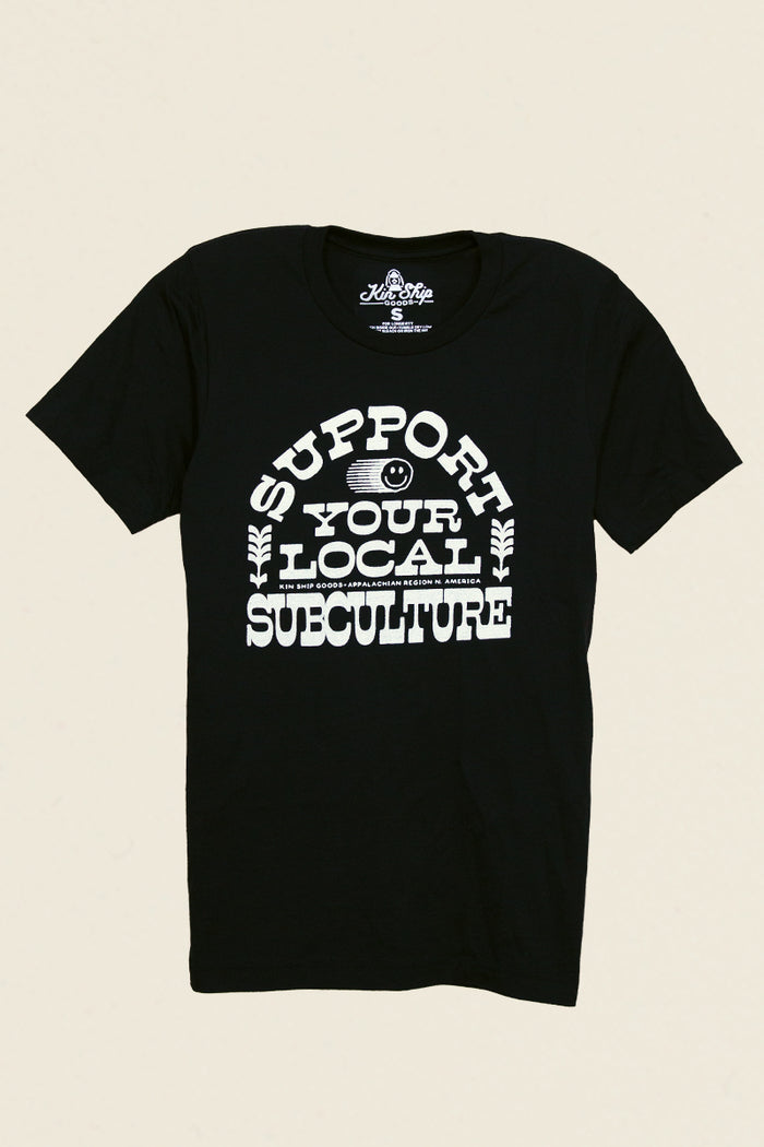Kin Ship Goods black tee with bold white ‘Support Your Local Subculture’ text and smiley face graphic, Appalachian-made.