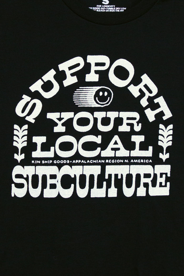 Kin Ship Goods black tee with bold white ‘Support Your Local Subculture’ text and smiley face graphic, Appalachian-made.