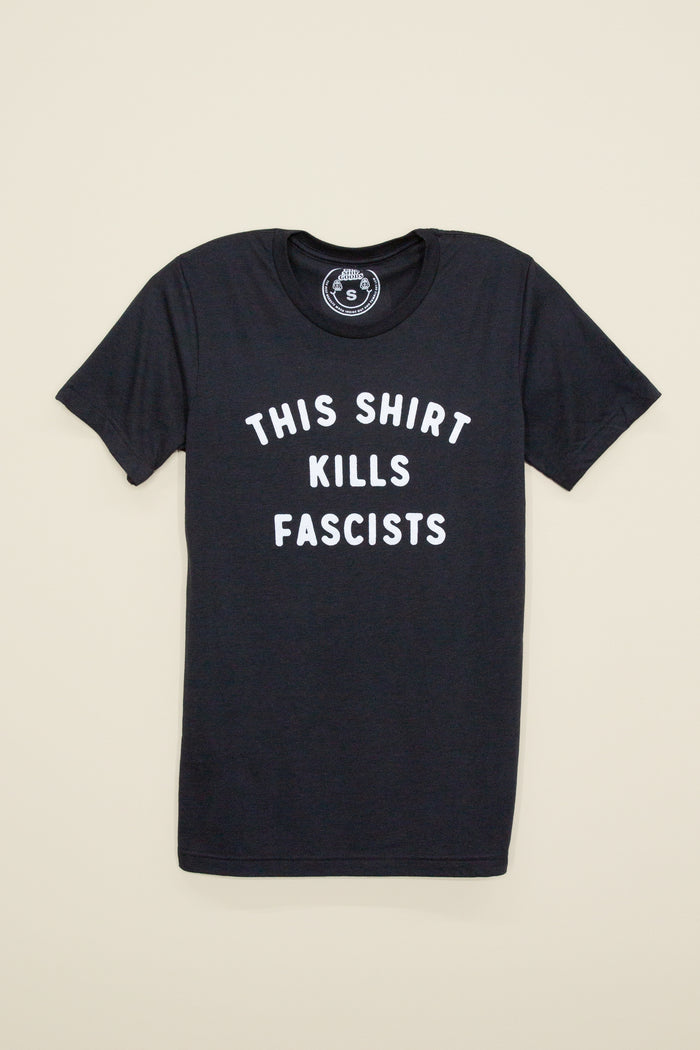 Kin Ship Goods black tee with white text reading 'This Shirt Kills Fascists,' inspired by Woody Guthrie.