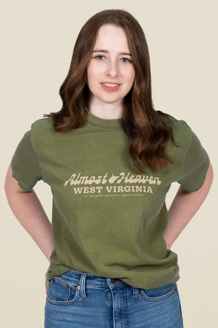 Kin Ship Goods olive green t-shirt with 'Almost Heaven West Virginia' text in vintage script across the chest.